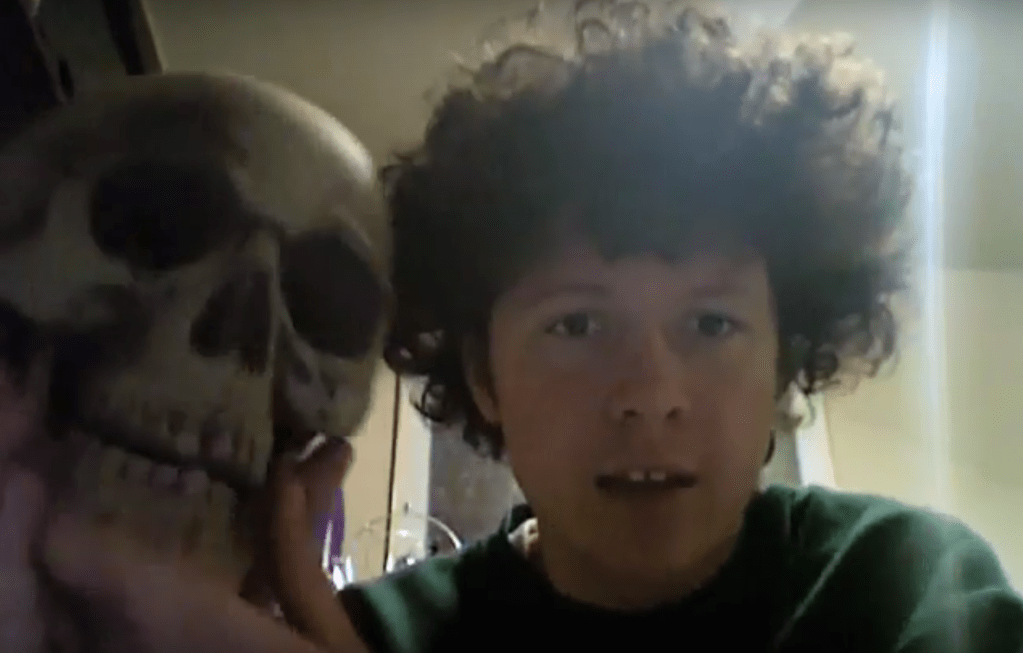 Screenshot of Reilly with a plastic skull named Julio from the webseries Reilly's Dorm.