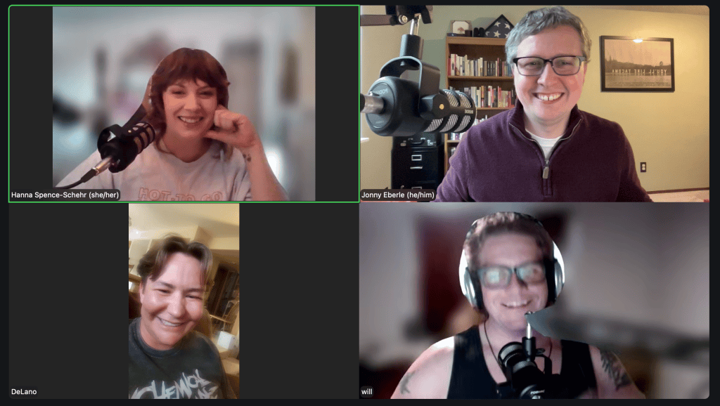 Screenshot of a Zoom meeting with four people smiling. Most have microphones visible in the frame.